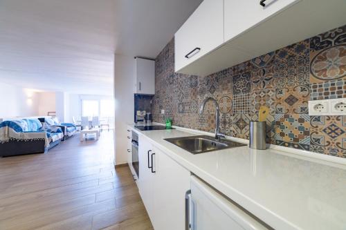a kitchen with a sink and a living room at AlmeriaSuite Roca 2 Mojacar in Mojácar