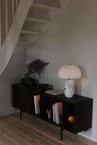 a table with a lamp and a shelf with books at Hótel Karólína in Stykkishólmur