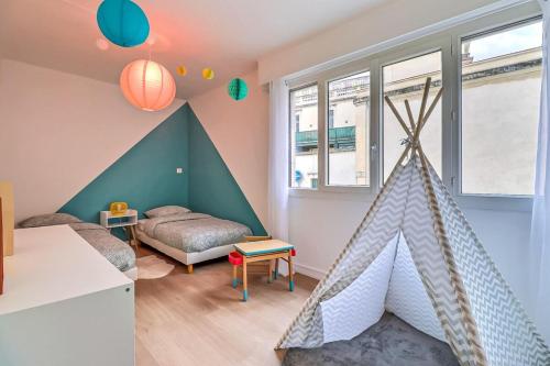 Cet appartement comprend une chambre dotée d'un lit et de fenêtres. dans l'établissement Atlas - Superbe logement plein centre - Terrasse, à Nîmes