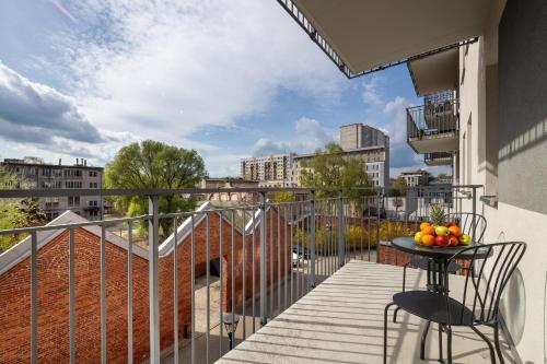 balkon ze stołem i owocami w obiekcie Bright Apartment with Balcony Close to the Poniatowski Park Łódź by Renters w Łodzi