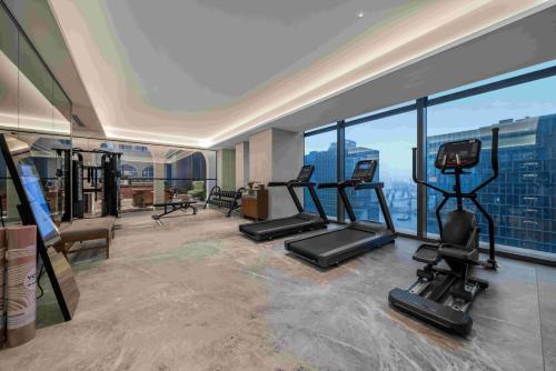 uma academia com esteiras e equipamentos de ginástica em um prédio em Shenzhen Shekou Prince Bay Yifei Hotel em Shenzhen