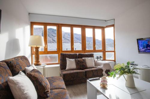 a living room with two couches and a table at Rural apartment in the mountains in Panticosa