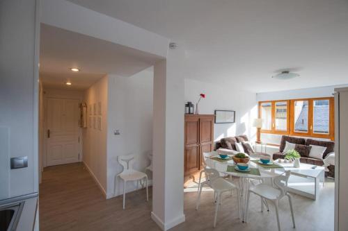 a living room and kitchen with a table and chairs at Rural apartment in the mountains in Panticosa