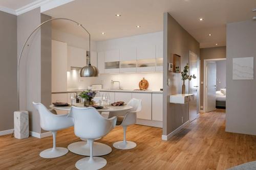 a kitchen with white chairs and a table in a room at Huswell - Modern apartment in heart of Knokke with terrace in Knokke-Heist
