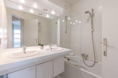 a white bathroom with two sinks and a shower at Huswell - Apartment for 4 near the coast and central Knokke in Knokke-Heist