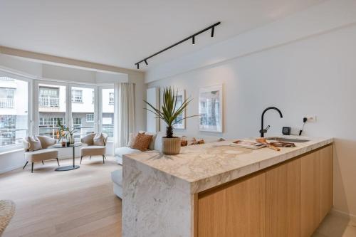 eine Küche mit einer Arbeitsplatte und ein Wohnzimmer in der Unterkunft Huswell - Trendy apartment on top location in Knokke for 7 in Knokke-Heist