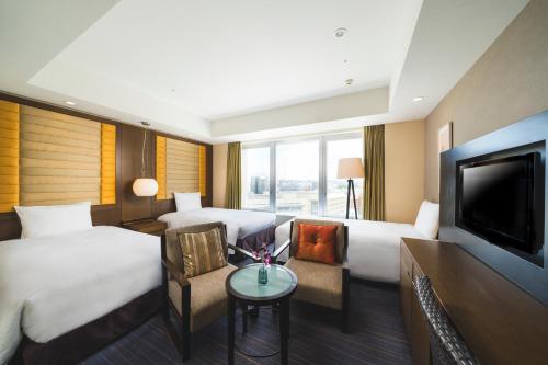 a hotel room with two beds and a flat screen tv at Rihga Royal Gran Okinawa in Naha