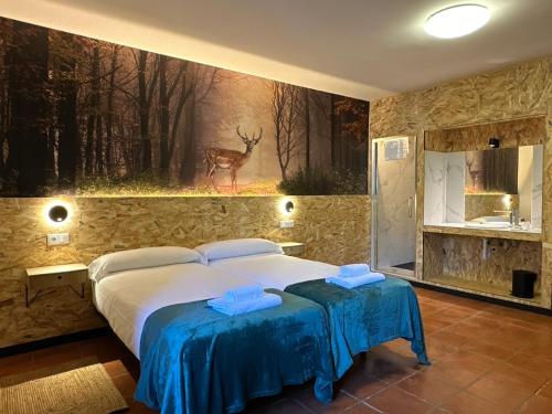 a bedroom with a bed and a painting of a deer at Albergue Real Fabrica de Ezcaray in Ezcaray