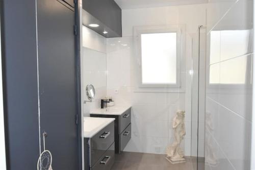 een witte badkamer met een douche en een wastafel bij La P.Dwelling Luxury House in Saint-Raphaël