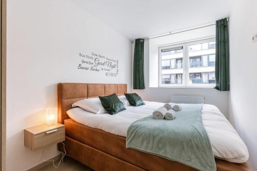 a bedroom with a bed with two pillows on it at Bright duplexapartment in Ostend