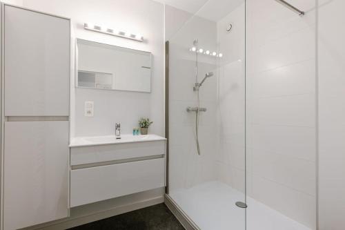 een witte badkamer met een wastafel en een douche bij Spacious apartment in Kortrijk in Kortrijk
