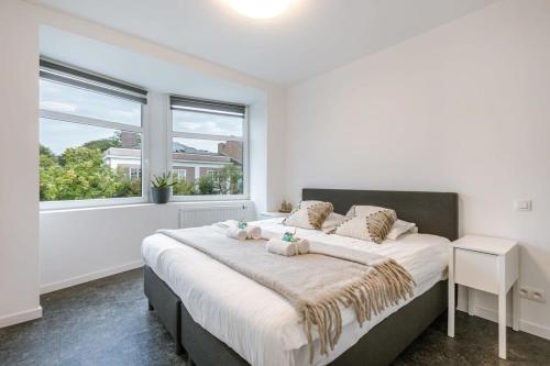 een slaapkamer met een groot bed met 2 teddyberen erop bij Spacious apartment in Kortrijk in Kortrijk