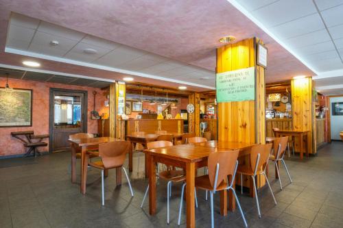 een eetkamer met houten tafels en stoelen bij HOTEL TURPÍ in Benasque