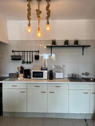 a kitchen with white cabinets and a microwave at Jupiter Sweet Apartments - Algarve - Praia Vale centeanes in Lagoa