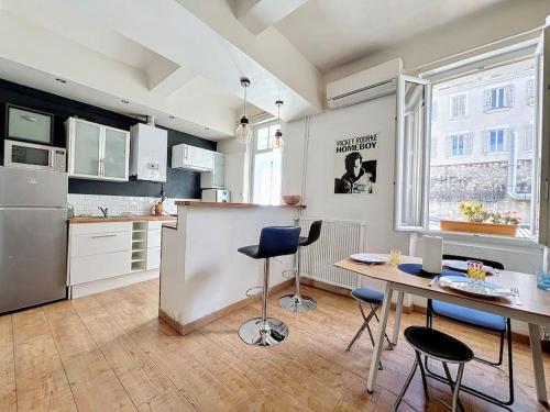 une cuisine avec une table et quelques chaises dans l'établissement Appartement Cours Julien - Central & Climatisation - Les Frères de la Loc', à Marseille