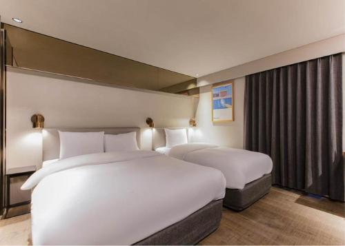 a hotel room with two beds and a window at Sillim Dominique Hotel in Seoul