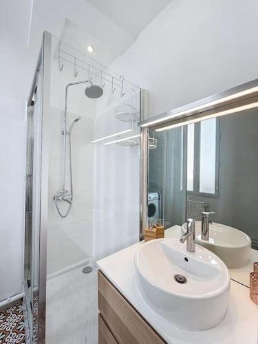 une salle de bain blanche avec un lavabo et une douche dans l'établissement Appartement Cours Julien - Central & Climatisation - Les Frères de la Loc', à Marseille