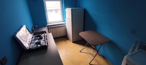 a small blue room with a refrigerator and a chair at Sərin göl istirahət mərkəzi in Quba