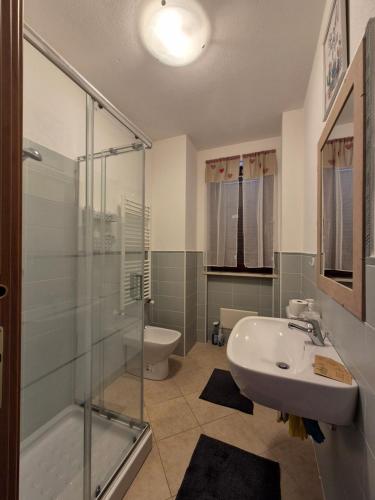 y baño con ducha acristalada y lavamanos. en Cozy accommodation in Sardinia, Olmedo, en Olmedo