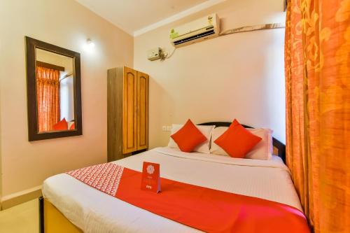 een slaapkamer met een bed met oranje en witte kussens bij Hotel Pillar'S Near Immaculate Conception Church in Oud Goa