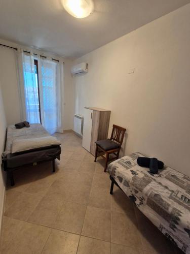 Habitación con 2 camas y una silla. en Cozy accommodation in Sardinia, Olmedo, en Olmedo