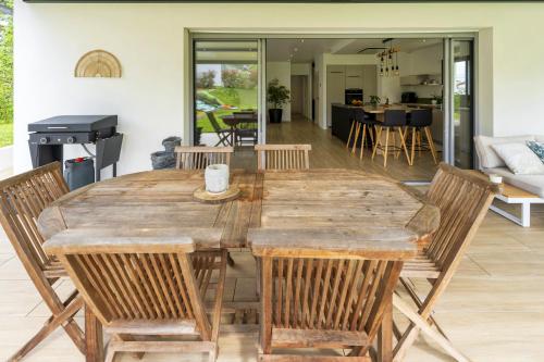 une table et des chaises en bois dans un salon dans l'établissement Villa Iguski, à Saint-Pierre-dʼIrube