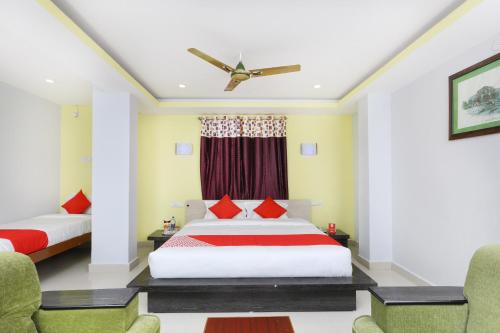 a bedroom with two beds and a ceiling fan at Hotel Sai Golden Rooms in Tirupati