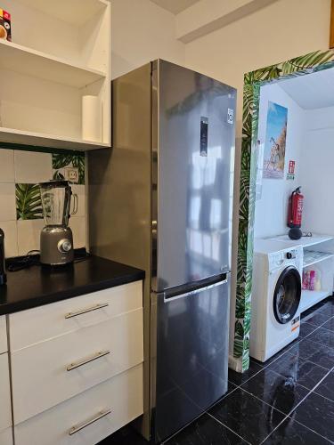 a kitchen with a refrigerator and a washer and dryer at SB Alojamento in Amora