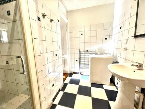 La salle de bains est pourvue d'un sol en damier noir et blanc. dans l'établissement Joli appartement en centre ville, à Bagnères-de-Bigorre