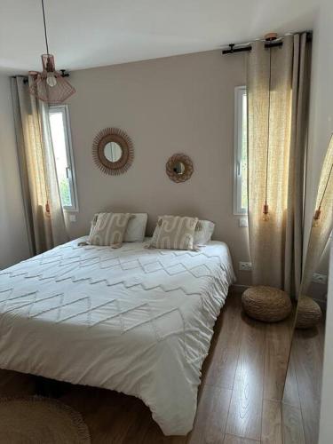 une chambre avec un grand lit avec des draps blancs dans l'établissement Jolie maison de vacances, à Bassussarry