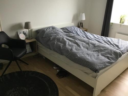 uma cama num quarto com uma cadeira e uma secretária em Stor lejlighed tæt på Århus C. Stor tagterrasse em Aarhus