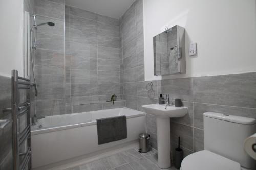 a bathroom with a tub and a toilet and a sink at Superb One Bedroom Apartment in Dundee in Dundee