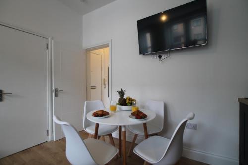 a white dining room with a white table and chairs at Superb 1-Bed Apartment - Free Parking Dundee in Dundee