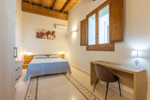 a bedroom with a bed and a desk and a window at Villa Daisy in Caprarica di Lecce