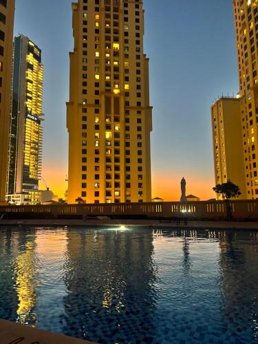 duży zbiornik wody z wysokimi budynkami w obiekcie Hostel Resort VIP w Dubaju