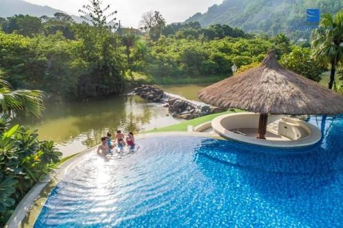 grupa osób w basenie w ośrodku w obiekcie Resort Xanh Villa 5 Stars w mieście Nam Giao