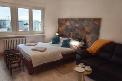 um pequeno quarto com uma cama e um sofá em Work & Stay Zagreb em Zagreb