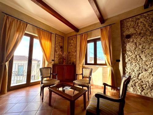 a living room with chairs and a table and windows at Luxury Accommodation in Santa Domenica