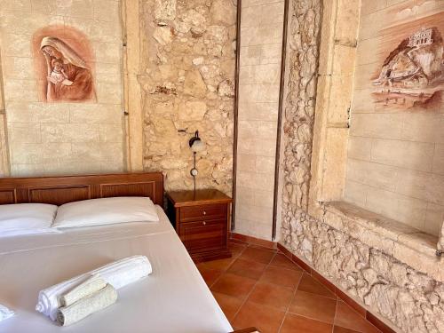 a bedroom with a bed and a stone wall at Luxury Accommodation in Santa Domenica