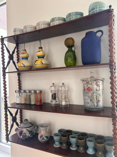 a shelf filled with lots of different colored vases at Maison Georges in Tourcoing