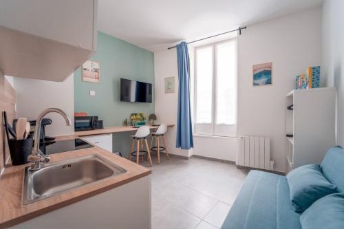 une cuisine avec un évier et un canapé dans une chambre dans l'établissement Atlas - Troie, à Saint-Thibéry