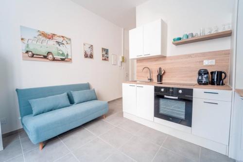 - une cuisine avec un canapé bleu dans une chambre dans l'établissement Atlas - Troie, à Saint-Thibéry