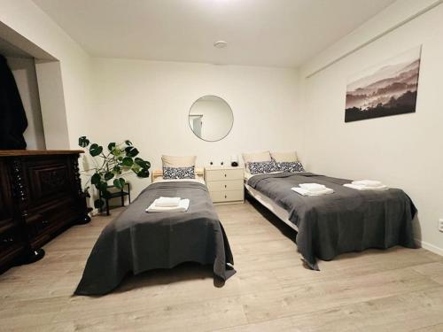 um quarto com 2 camas e um espelho em 7 Soverom i hjertet av Bergen em Bergen