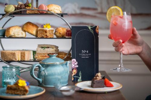 a person holding a drink next to a table with food at The Rodney Hotel in Bristol