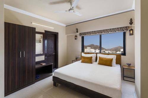 1 dormitorio con cama y ventana grande en Lazy Daze by UCH en Udaipur