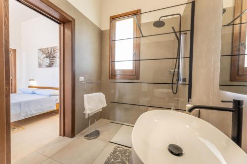 ein Bad mit einer Badewanne und einer Dusche sowie ein Bett in der Unterkunft Villa Daisy in Caprarica di Lecce