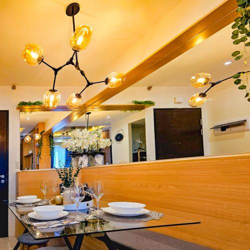 a dining room with a table and a chandelier at The Luxury Lounge in Bacolod