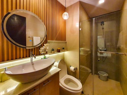 a bathroom with a sink and a toilet and a mirror at The Luxury Lounge in Bacolod