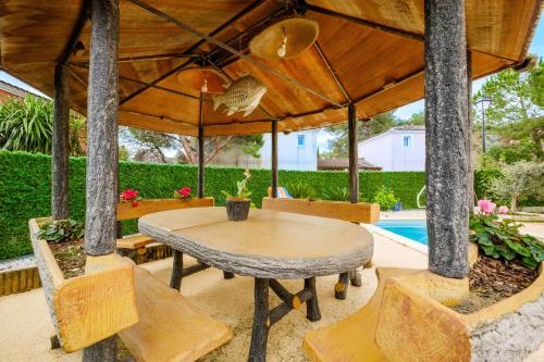 un patio avec une table et des chaises et une piscine dans l'établissement Villa Gnoki, à Cannes