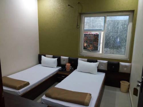 - 2 lits dans une chambre avec fenêtre dans l'établissement MAHADEV GUEST HOUSE, à Kokkíni Khánion